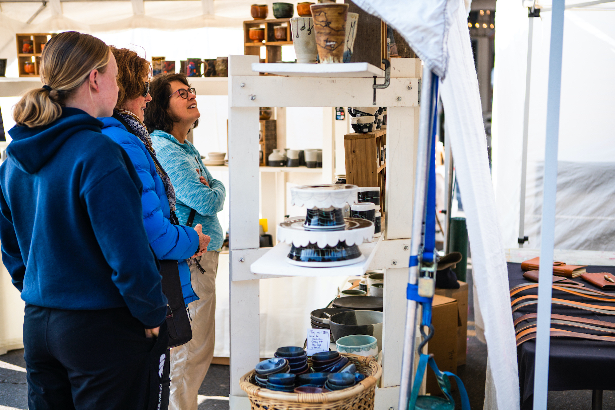 Three women admire ceramics at the Fall Arts Festival on the town square in Jackson Hole.