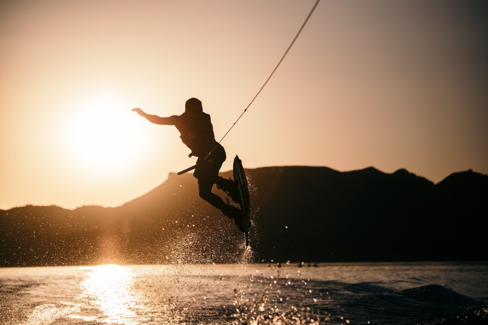 A wakeboarder catches air at sunset.