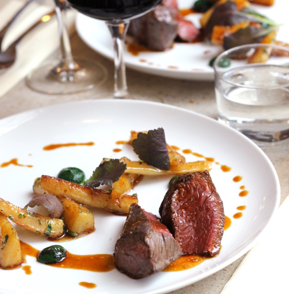 A rare piece of steak elegantly plated at Snake River Grill.