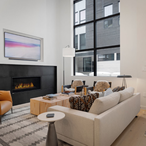 A cozy contemporary modern living room with floor-to-ceiling windows.